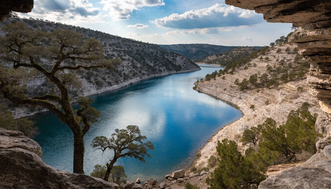 Blue reservoir water among limestone slopes and oak trees in a Texas Hill Country scene.